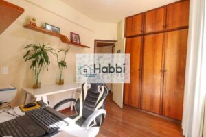 há um banheiro social com box e um quarto sendo suite com piso laminado